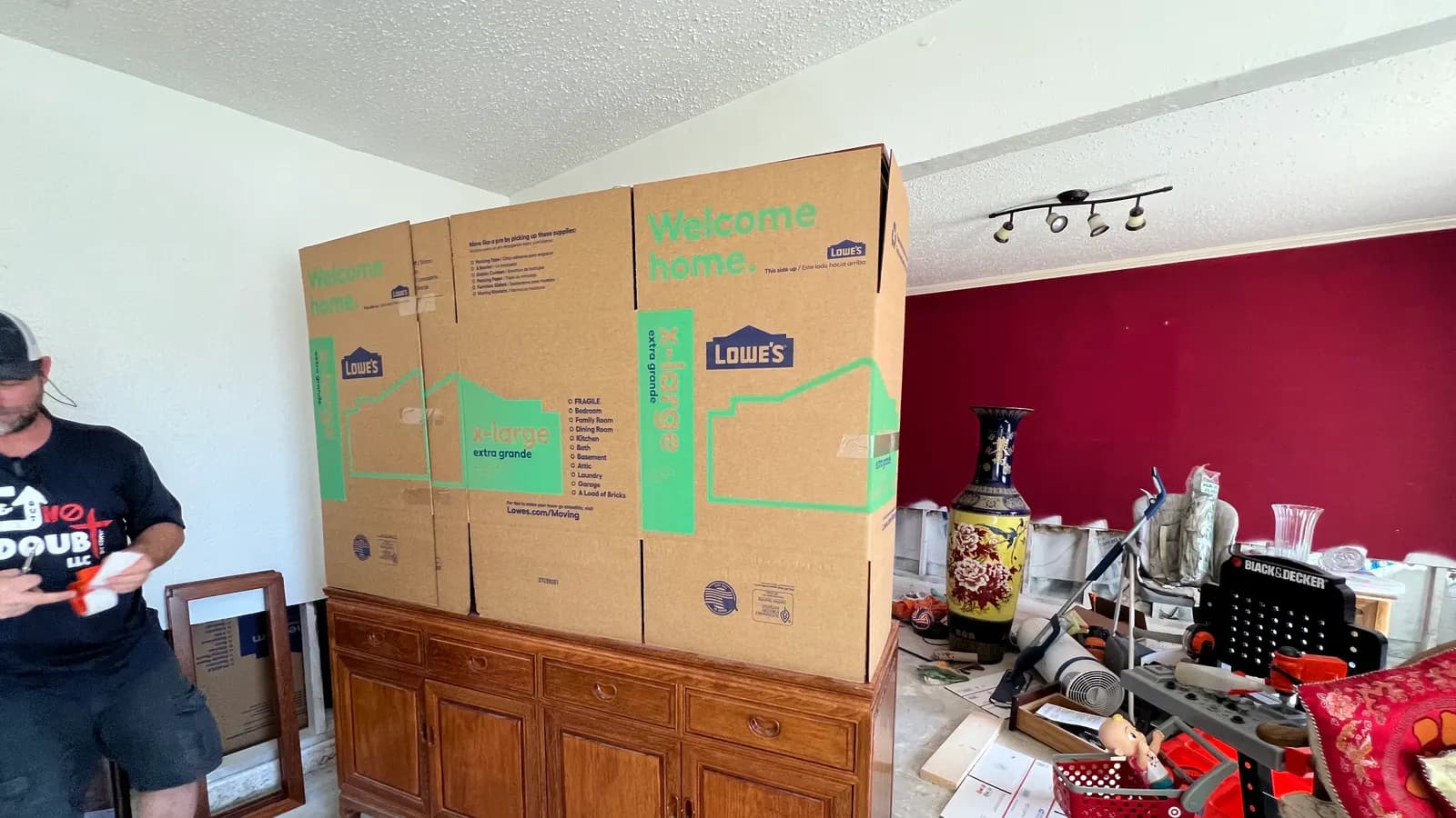 In & Out No Doubt mover prepping extra-large boxes to pack a wood sideboard in a client's home