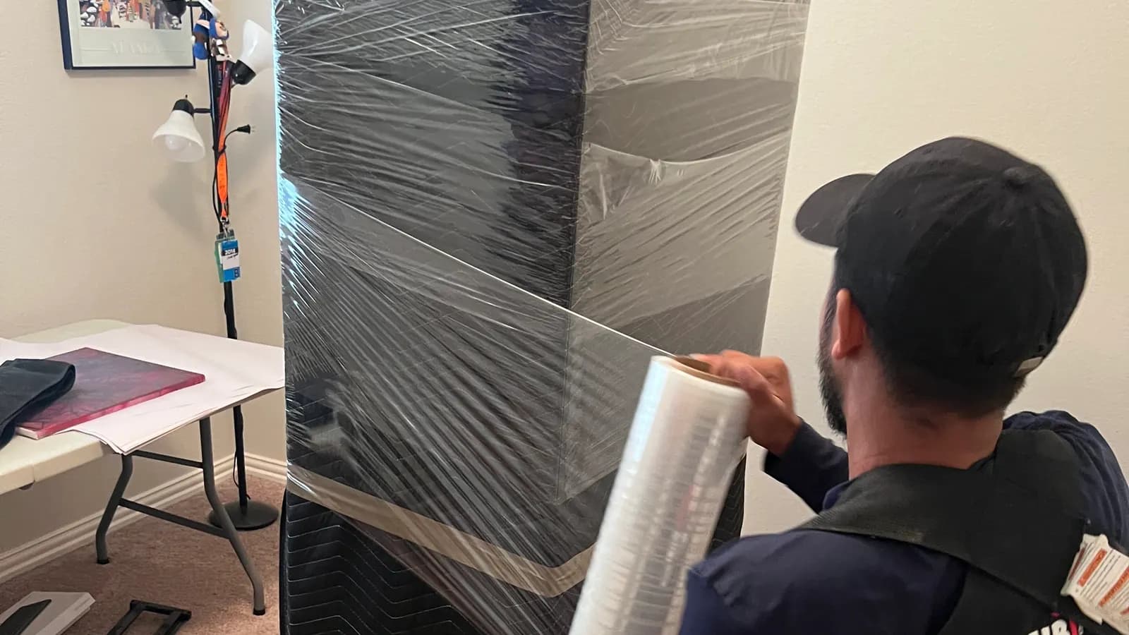 In & Out No Doubt mover stretch-wrapping a blanket-padded headboard in a customer's home
